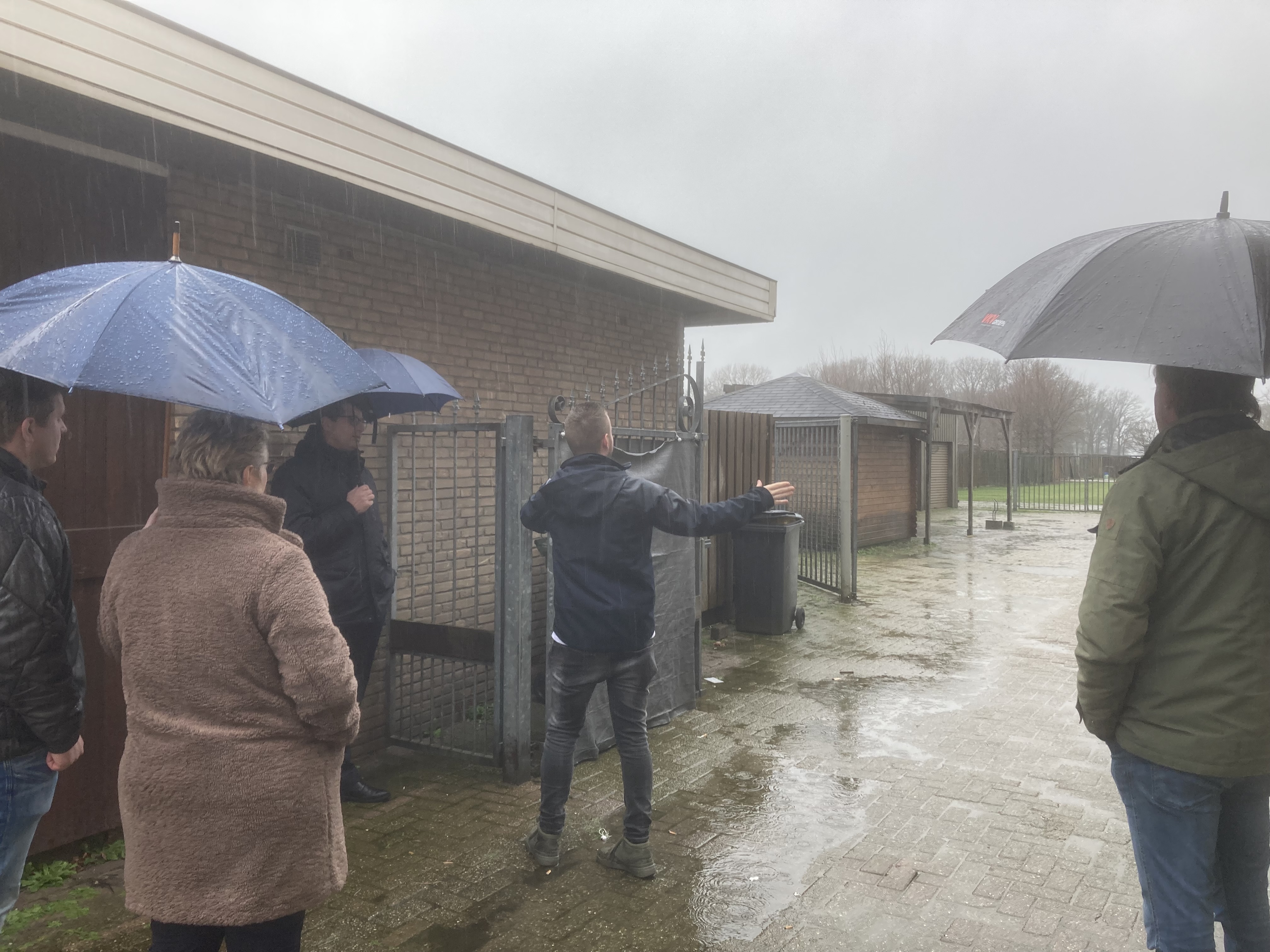 In de stromende regen bezoeken de gedeputeerde en raadsleden de Essenseweg en De Lind in Nispen