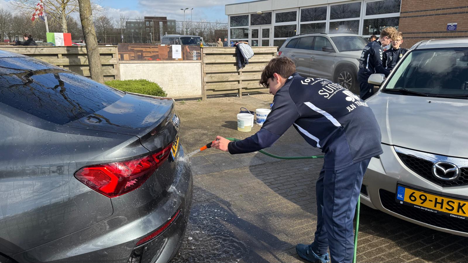 De auto's bij de Internos wasstraat worden na het insoppen netjes afgespoten.