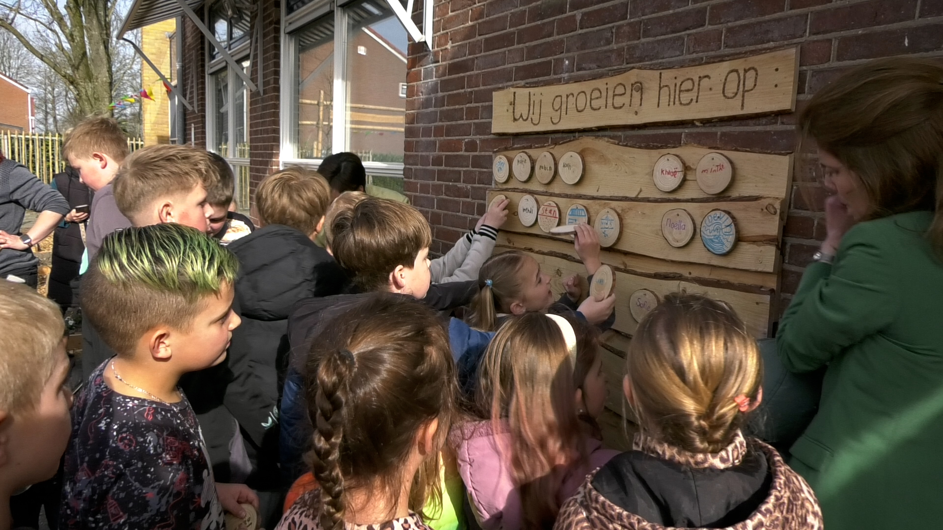 De namen van de leerlingen worden aan de muur gehangen.