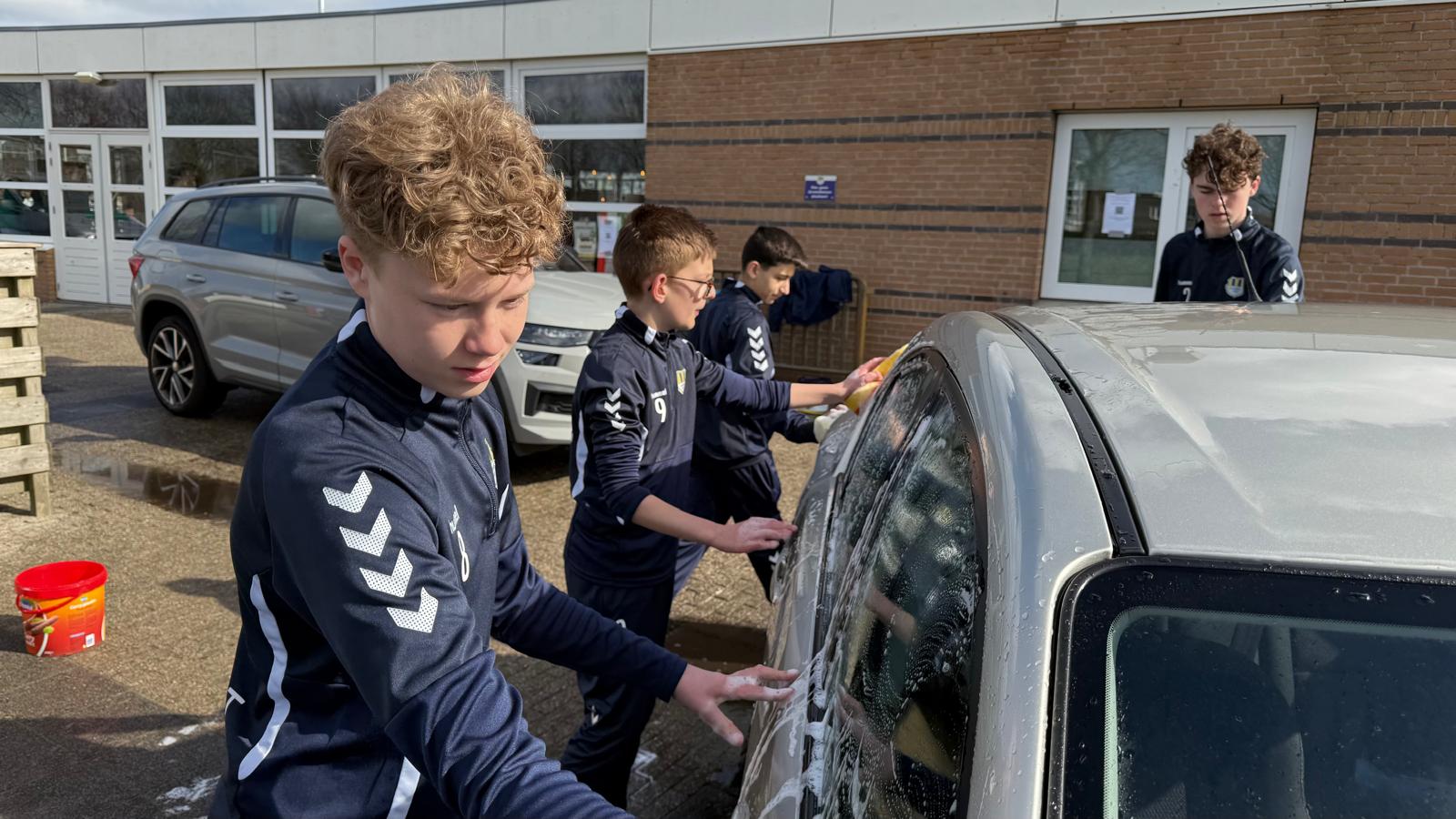 Internos Etten-Leur - De voetballers zijn druk bezig met het wassen van auto's.