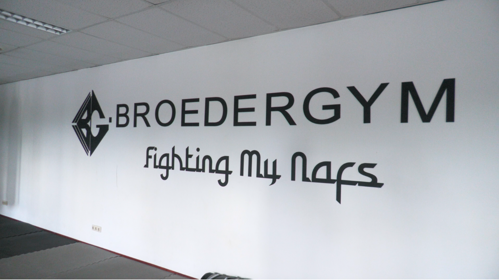 Naam van de sportschool met daaronder het motto "Fighting My Nafs"