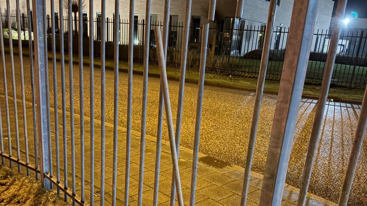 Het ijzeren hek van het betaalde gedeelte van het transferium wordt opengebroken.