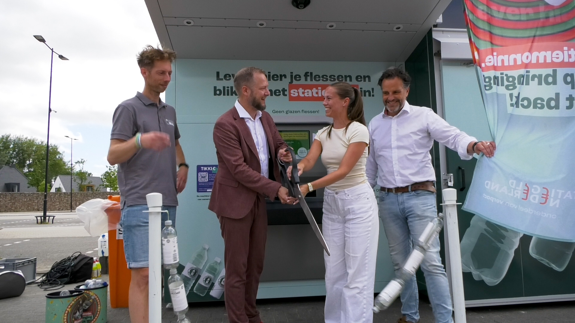 Wethouder Berend Doedens en Lisanne Korten van De Zeeland knippen het lint van plastic flesjes door